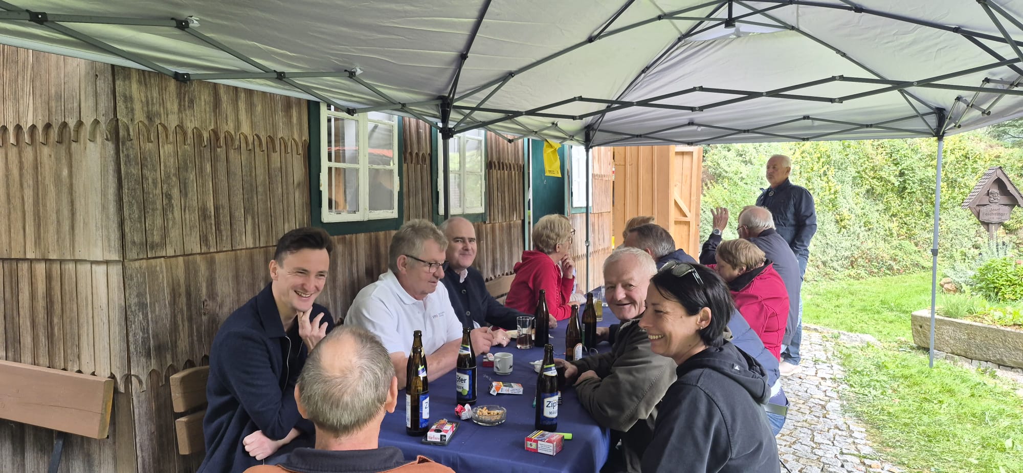 Gäste sitzen beim Frühschoppen gemeinsam an einem gedeckten Tisch