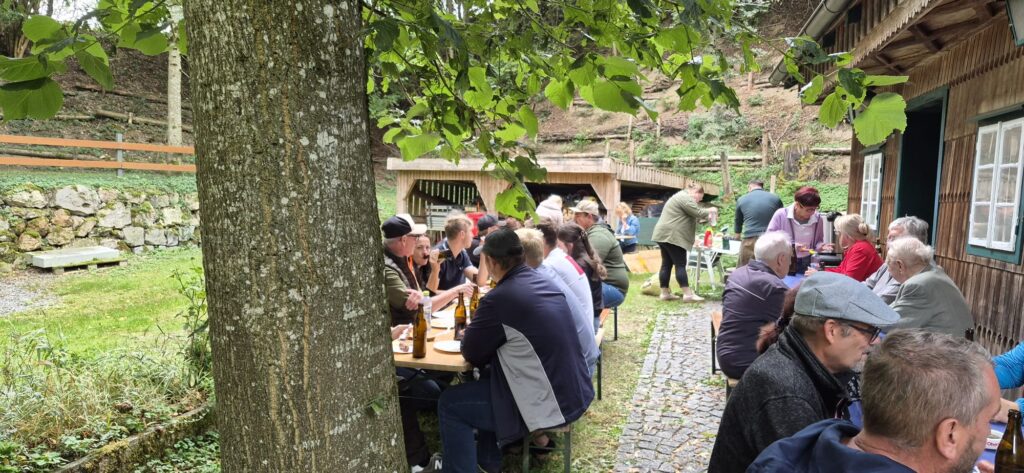 Gäste beim Sommerfest der FPÖ Eitzing im Freien neben der Holzhütte